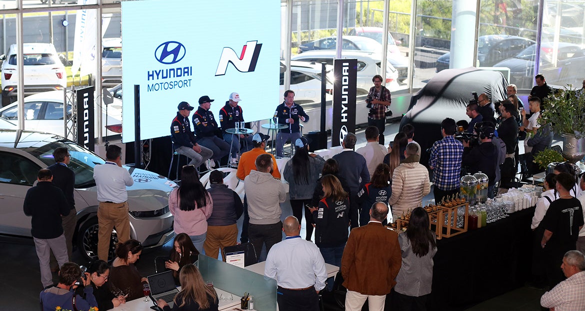 pilotos de Hyundai Motorsport posando junto a un automóvil durante un evento